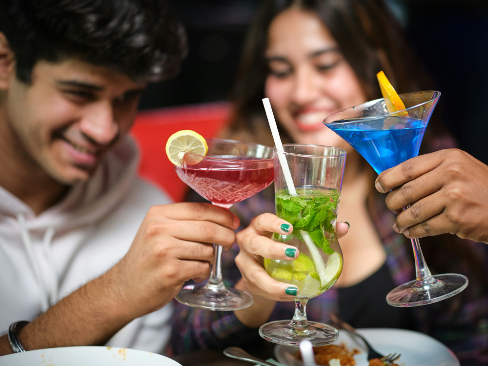 A group of Canadian friends clinking non-alcoholic drinks to save money